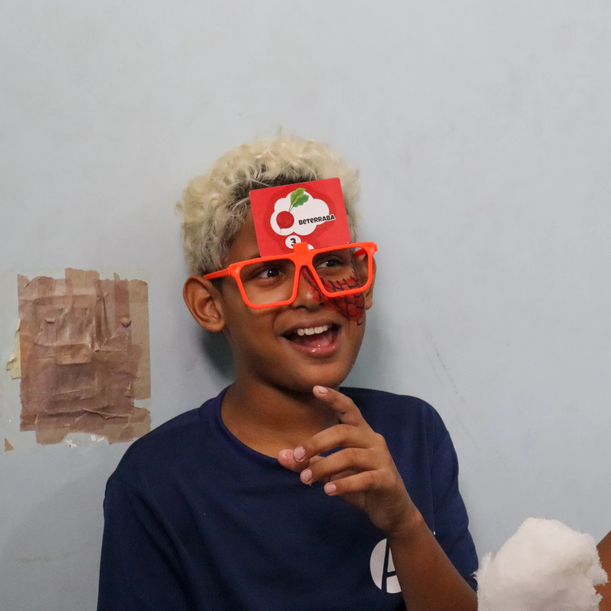 Criança usando óculos vermelhos e adereço de pirata