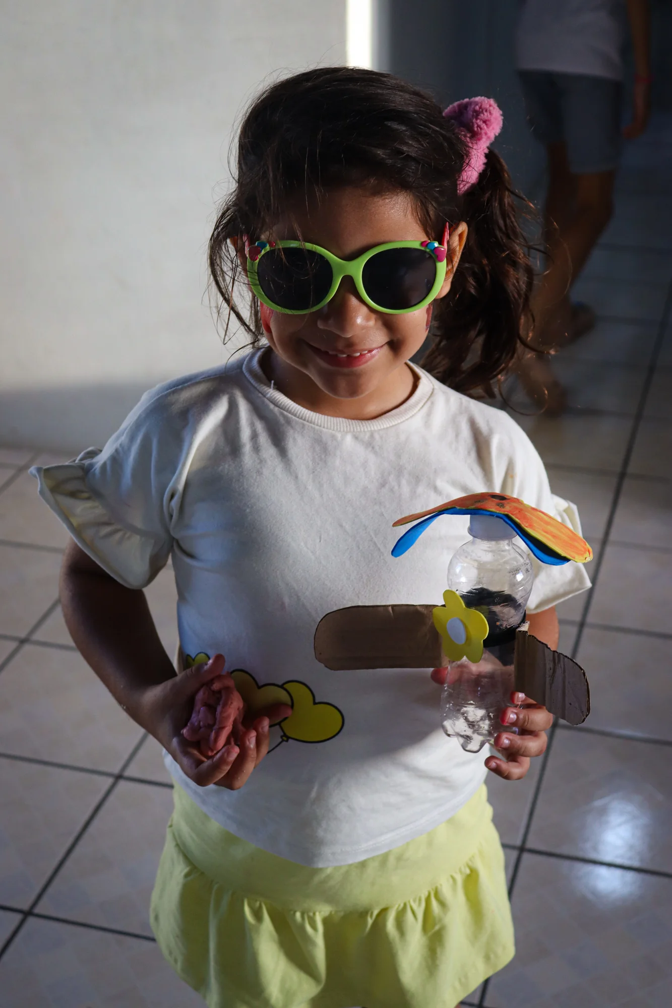 Menina usando óculos verdes e acessórios coloridos