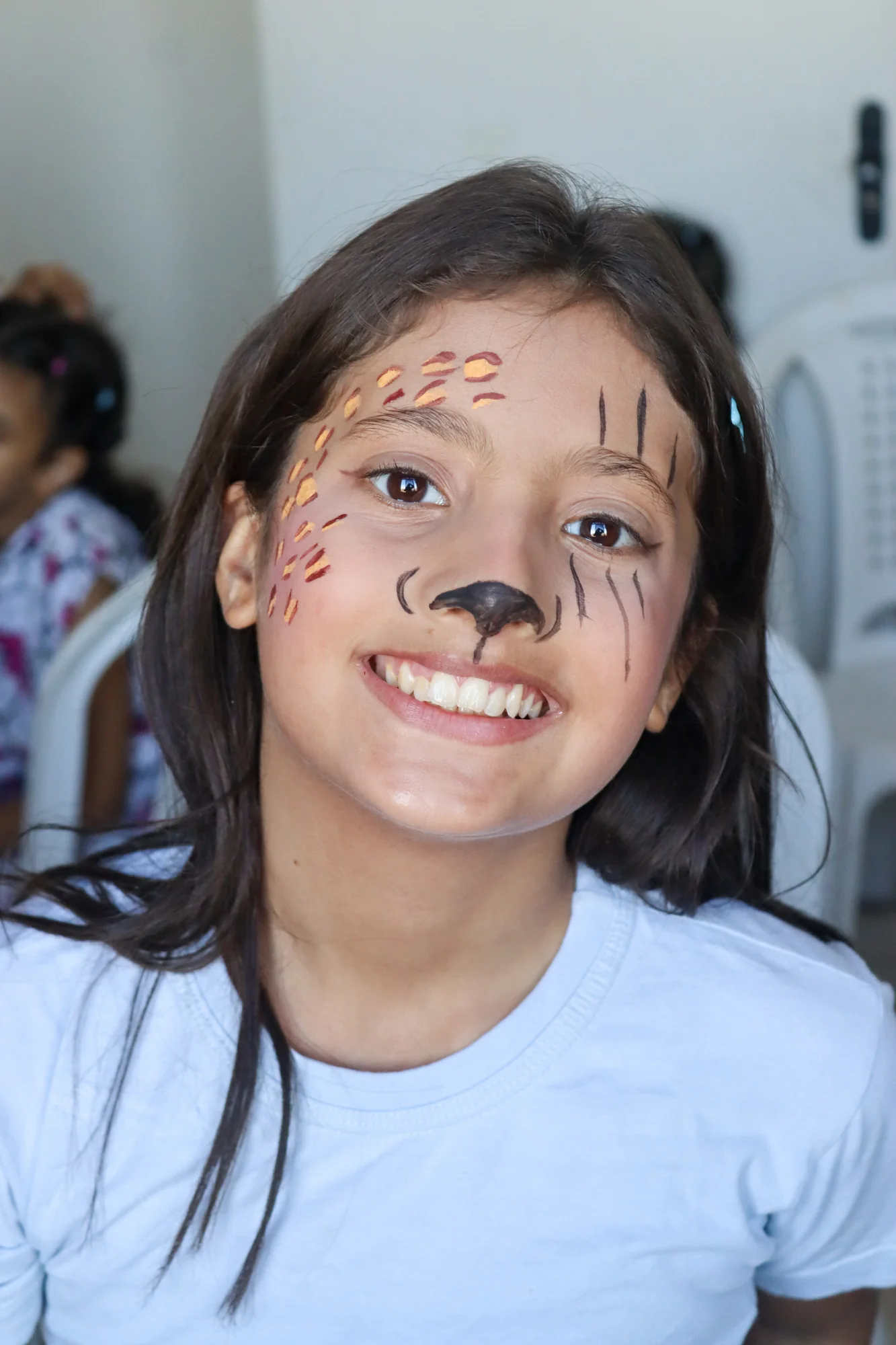 Menina sorrindo com pintura artística de animal no rosto